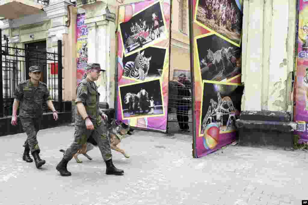 Российские солдаты 25 июня проходят мимо ворот в Ростове-на-Дону, где накануне стоял танк «Вагнера»