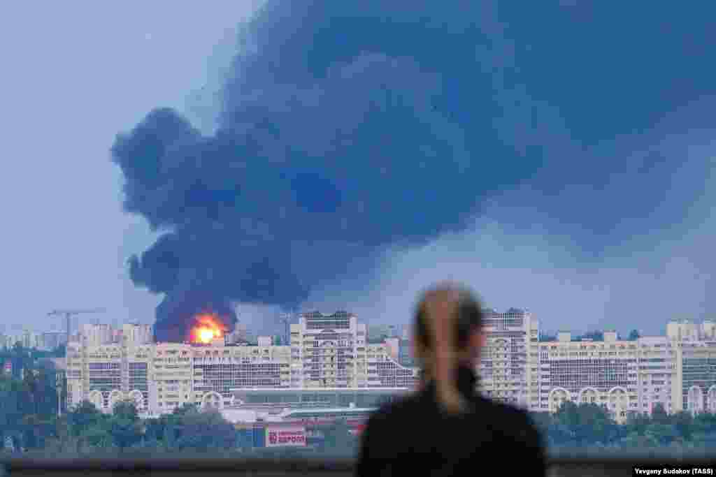 A woman watches a fuel tank burning in Voronezh, southern Russia, on June 24. The fuel tank exploded as a Russian military helicopter flew near it during the short-lived uprising by the Wagner mercenary group. 