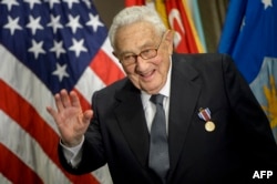 Kissinger maše nakon što je primio nagradu tokom ceremonije u Pentagonu u čast njegove diplomatske karijere 9. maja 2016.