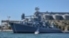 Рыбаки на лодке «Путина» в Севастопольской бухте, в небе над ними два российских ударных вертолета, архивное фото