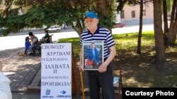 "Бипэк Авто – Азия Авто" компаниялар тобының қамаудағы қызметкерлерін қолдауға пикетке шыққан белсенді Леонид Карташев. 8 маусым, 2022 жыл. Сурет Flashpress.kz сайтынан алынды.