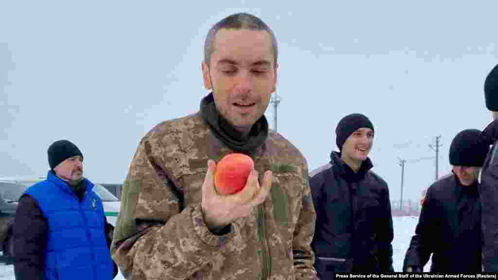 Această imagine din 4 februarie 2023 arată un soldat ucrainean recent eliberat care ține în mână un măr, pentru prima dată după un an de captivitate. Înregistrarea video de la fața locului arată cum bărbatului nu-i vine să creadă că mușcă din acel fruct. Imaginea este una dintre zecile de fotografii cu eliberarea deținuților, făcute în ultimul an, multe realizate în locații nespecificate din Ucraina, care arată emoția sinceră a bărbaților și femeilor întorși în brațele celor dragi. 