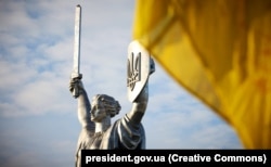 Во время празднований в День Государственного флага Украины. Киев, 23 августа 2023 года. На щите монумента сменили герб СССР на украинский тризуб