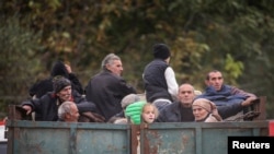 ARMENIA -Refugees from Nagorno-Karabakh ride in the back of a truck as they arrive in the border village of Kornidzor, September 26, 2023.