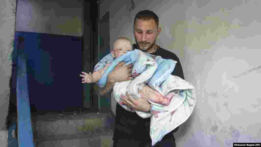 A man carries an injured baby following the missile strike. Reuters reported that the youngest injured was a 3-month-old child. The child's condition was not immediately known.