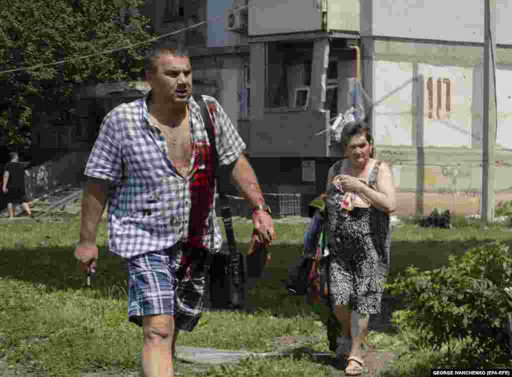 Injured residents flee their homes.