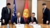 Навид Хассан Накви жана Алмаз Бакетаев макулдашууга кол коюп жаткан учур.