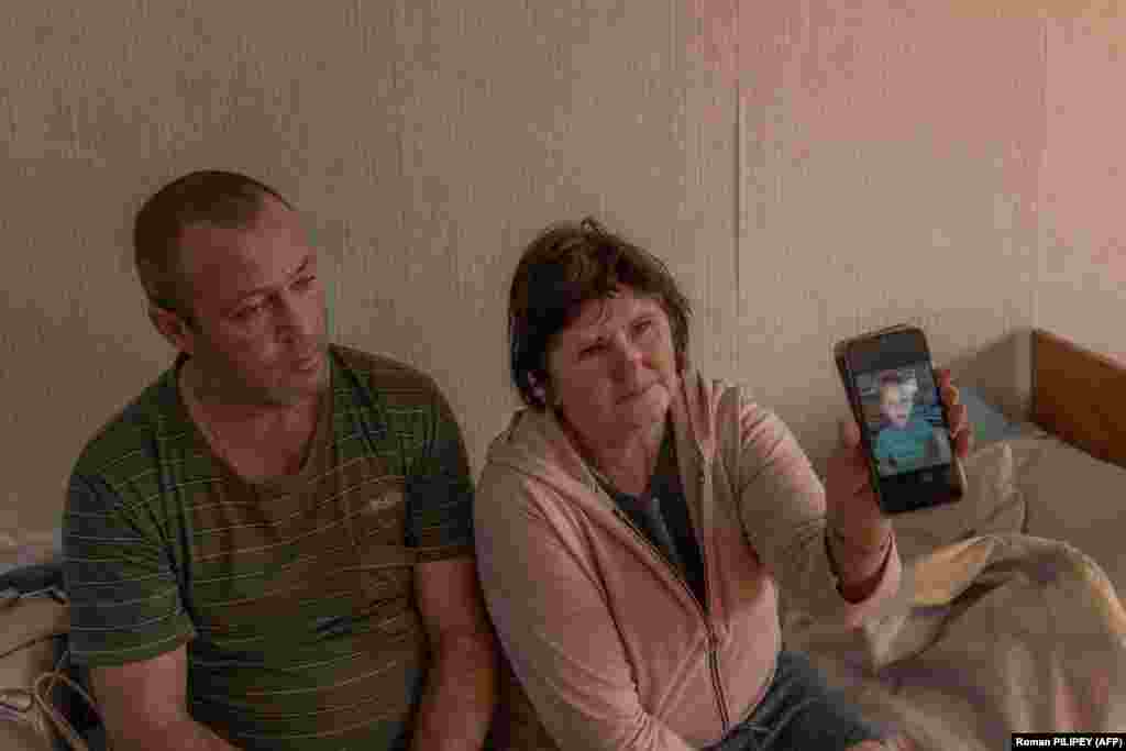 Genadij Grickov (43) sjedi pored svoje majke, Ljubov Sitnikova, u izbjegličkom centru dok pokazuje fotografiju svog 6-godišnjeg unuka, Nazara, koji je ubijen prošlog mjeseca u ruskom granatiranju regije Herson. Povrijeđen je i njen 13-godišnji unuk. Sada žive na mjestu bivšeg internata u Mikolajivu. &quot;Tog dana smo trebali slaviti sinov rođendan. Unuk mi je rekao da želi ići u školu, da želi naučiti pisati. Nije uspio&quot;, kaže Ljubov kroz suze.