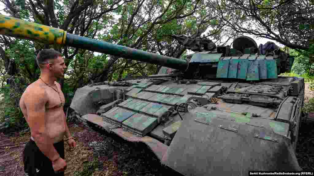 A Ukrainian soldier stands near a T-80 tank, which was captured from the Russian Army.