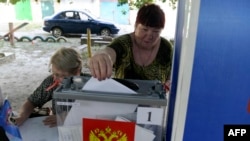 Украинанын Орусия аннексиялап алган Донецк шаарында өткөрүлүп жаткан мыйзамсыз шайлоодо добуш берип жаткан аял. 6-сентябрь, 2023-жыл. 