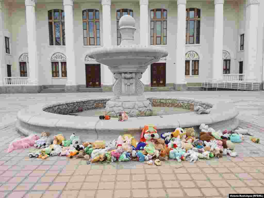 Импровизированный мемориал погибшим во время войны детям перед Дворцом культуры в городе Новая Каховка Херсонской области. «Это здание напротив российской комендатуры, — сказал проходивший мимо мужчина. — Приносят сюда игрушки, чтобы они видели и помнили» 