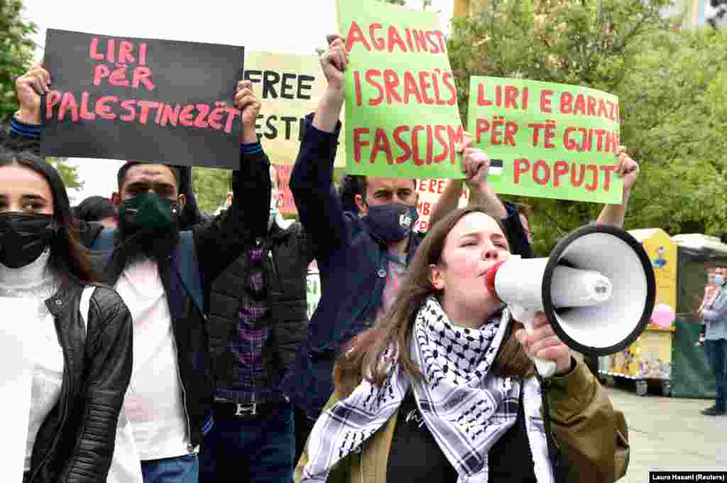 Shqiptarët e Kosovës brohoritin sllogane dhe mbajnë banderola kundër dhunës në Gazë, dhe në mbështetje të një Palestine të lirë, gjatë një marshi në Prishtinë, më 14 maj 2021.