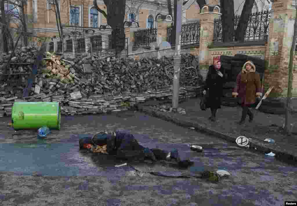 Жарадар болгон киши жерде жатат
