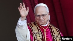 Papa Leon al XIV-lea face cu mâna mulțimii, de pe balconul central al Bisericii Sfântul Petru de la Vatican, după alegerea sa în fruntea Bisericii Catolice de către conclavul cardinalilor, pe 8 mai 2025 