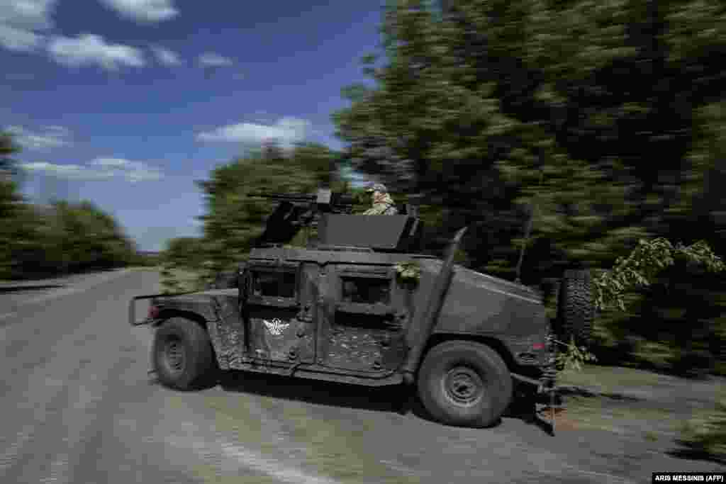 Украинский военнослужащий на Humvee американского производства, мчащемся к линии фронта. Вашингтон направил украинским вооруженным силам сотни машин Humvee 