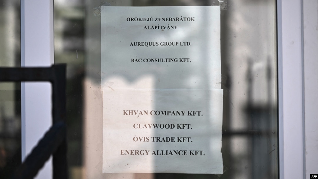 Different company names, among them the BAC Consulting KFT, are displayed at the entrance to the building housing them, on September 18 in Budapest.