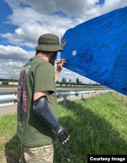 Шота Битадзе оставляет подпись на дорожном указателе в Украине