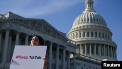 Вашингтондо Капитолийдин жанында TikTok тиркемесин колдор чыккае кыз. 