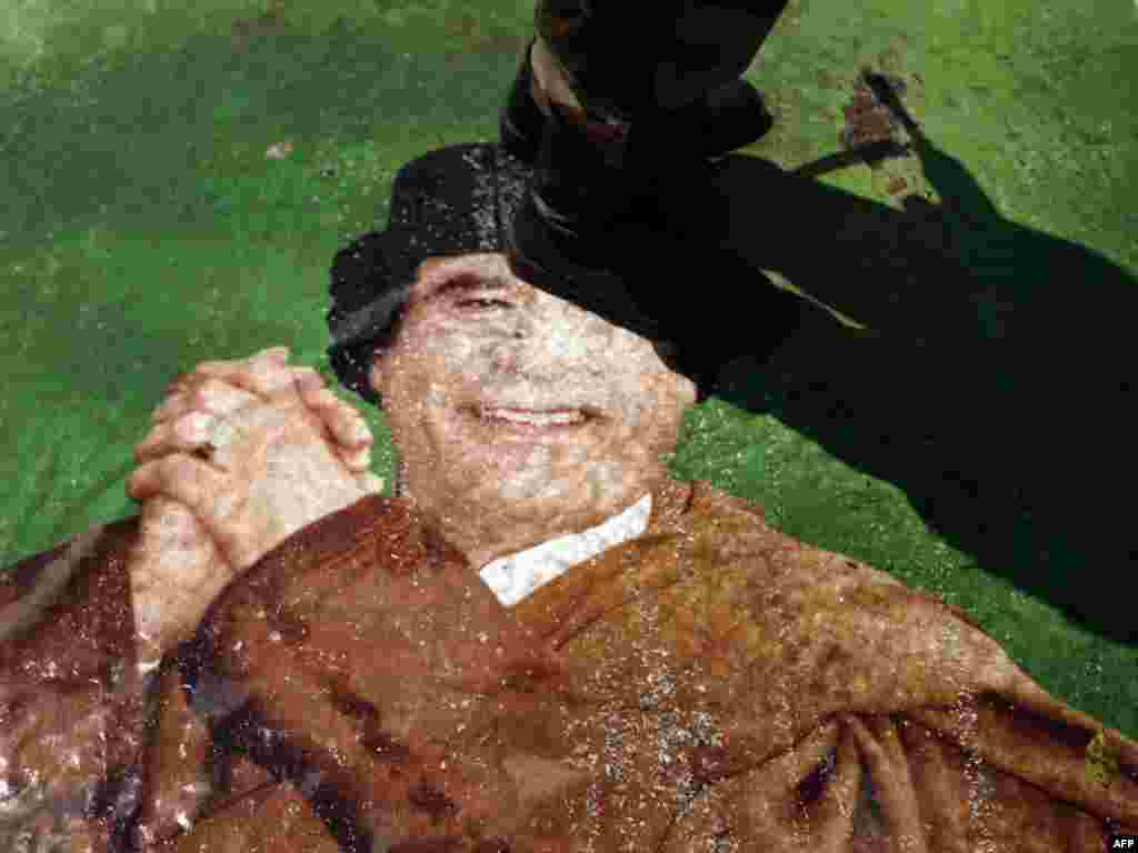 یکی از مخالفان معمر قذافی تصویر ویر را لگد میکند- بنغازی، اول تیرماه ۱۳۹۰