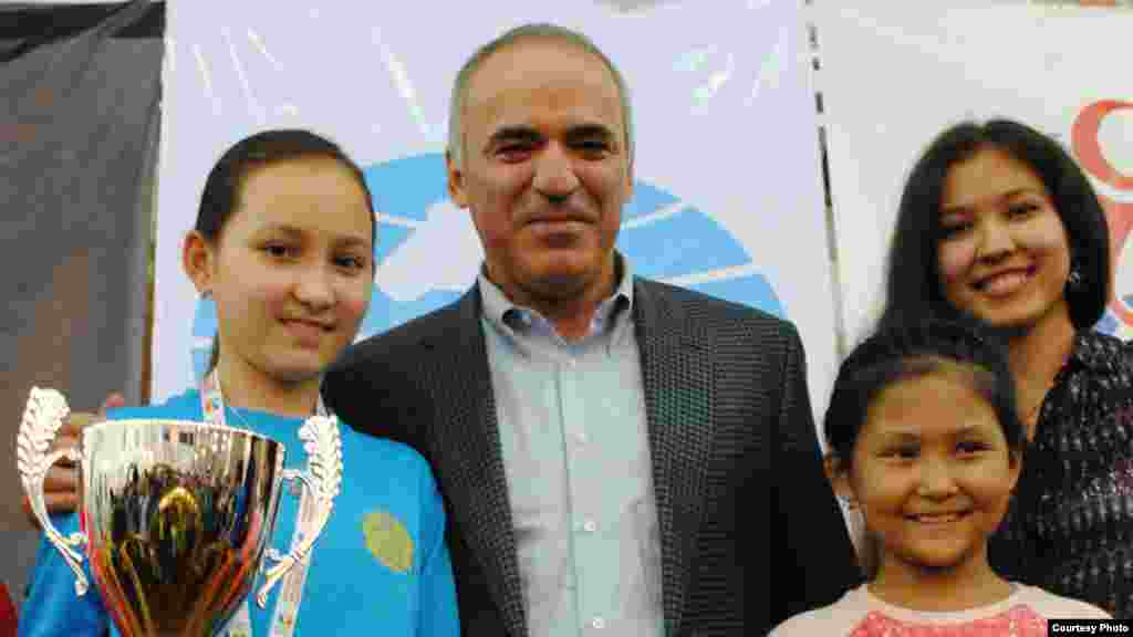 Жансая Әбдімәлік (сол жақта) шахматтан әлем чемпионы, халықаралық дәрежедегі гроссмейстер Гарри Каспаровпен (ортада) бірге.