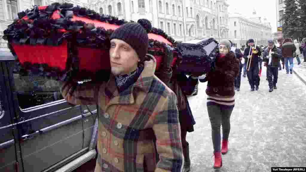 Траурная процессия прошла по улице Ильинка: несколько человек несли гробы с надписями "Профилактика" и "Лечение", оркестр играл траурный марш. 