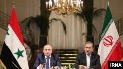 اسحاق جهانگیری (راست) معاون رییس‌جمهوری ایران همراه با عماد خمیس نخست‌وزیر سوریه در یک نشست خبری.