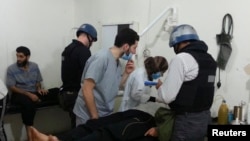 کارشناسان سازمان منع استفاده از سلاح‌های شیمیایی در حال معاینه افرادی که در اثر حملات شیمیایی حکومت سوریه مجروح شده اند.