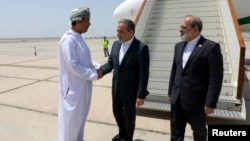 Iranian Foreign Minister Abbas Araqhchi (center) is welcomed by an unidentified Omani official upon his arrival in Muscat, Oman, for nuclear talks with the United States on May 11.