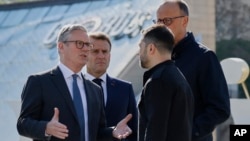 UK Prime Minister Keir Starmer, (left) talks to Ukrainian President Volodymyr Zelenskyy (second right) as French President Emmanuel Macron (second left) and German Chancellor Friedrich Merz look on after a group photo on Independence Square in Kyiv on May 10.