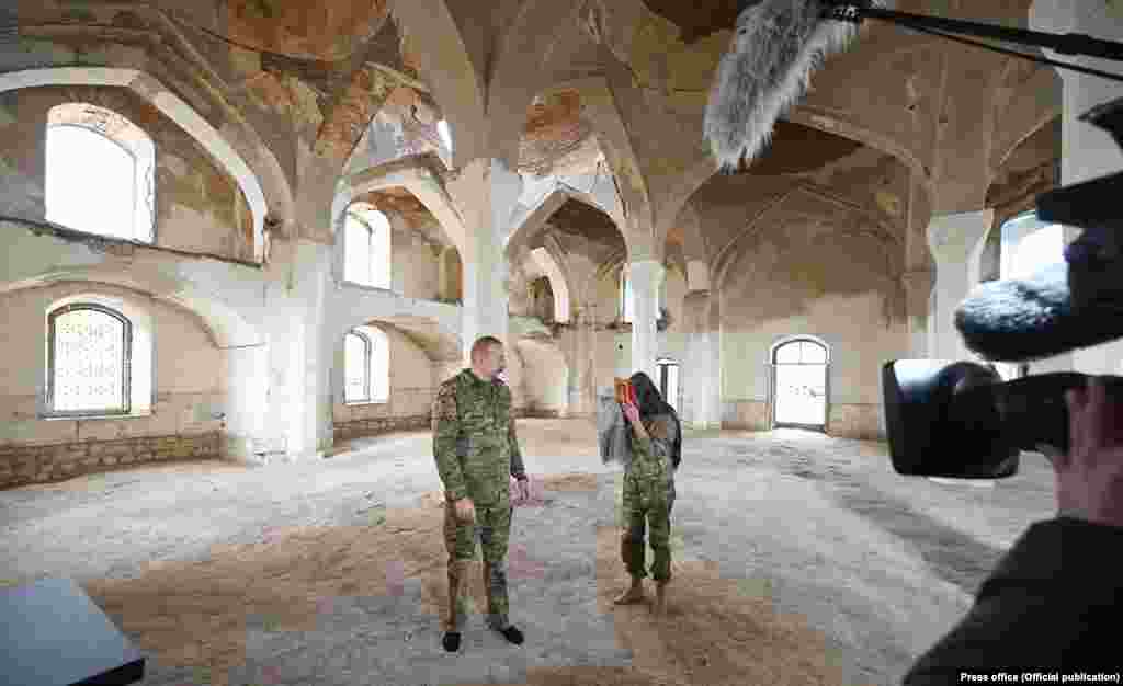 Ilham Aliyev azeri elnököt és feleségét – aki egyben az ország elnökhelyettese – november 22-én a Koránnal fényképezik a mecsetben. Lohr aggódik, mert nem könnyű a háborúval kapcsolatos érzelmeken túllépni, hiszen „annyi igazságtalanság történt ott".