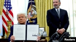 US President Donald Trump holds an executive order about tariffs increase while flanked by Commerce Secretary Howard Lutnick in Washington.