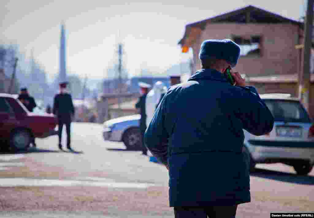 Телефон менен сүйлөшүп жаткан милиция кызматкери. 