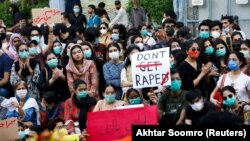 Protesters carry signs condemning violence against women and girls during a protest in Karachi on September 12.