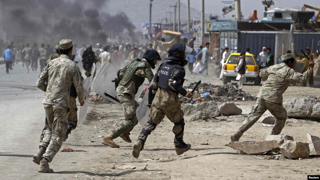 Afghan riot police run toward protesters during a demonstration in Kabul on September 17.