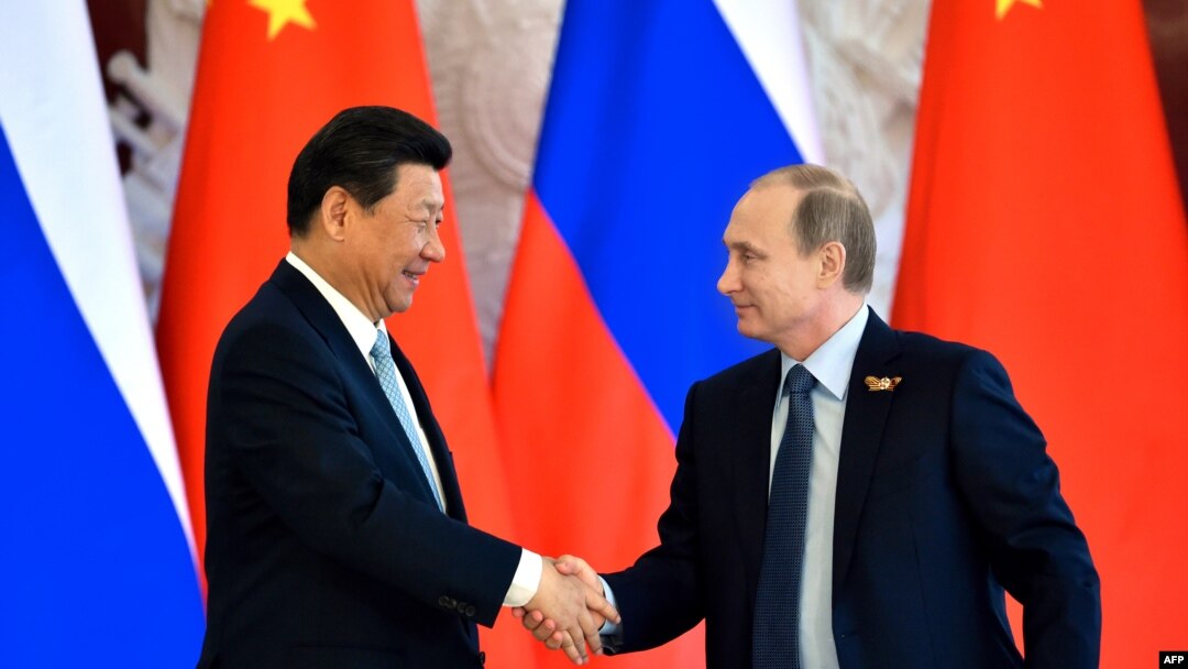 Russian President Vladimir Putin (right) shakes hands with his Chinese counterpart Xi Jinping in Moscow on May 8. 