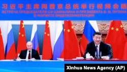 Chinese President Xi Jinping (right) speaks with Russian President Vladimir Putin via video conference on June 28, 2021.