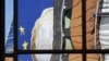 Reflektimi i monedhës së euros në fasadën e ndëstesës së Komisionit Evropian në Bruksel...