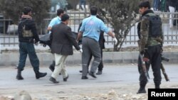 Afghan security forces carry the body of a victim at the site of a bomb blast in Kabul on February 21.