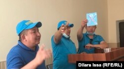 Белсенділер Ерлан Файзуллаев, Нұржан Әбілдаев және Жанмұрат Аштаев (солдан оңға қарай) сот үкіміне наразылық білдіріп тұр. Шымкент, 1 маусым 2021 жыл.