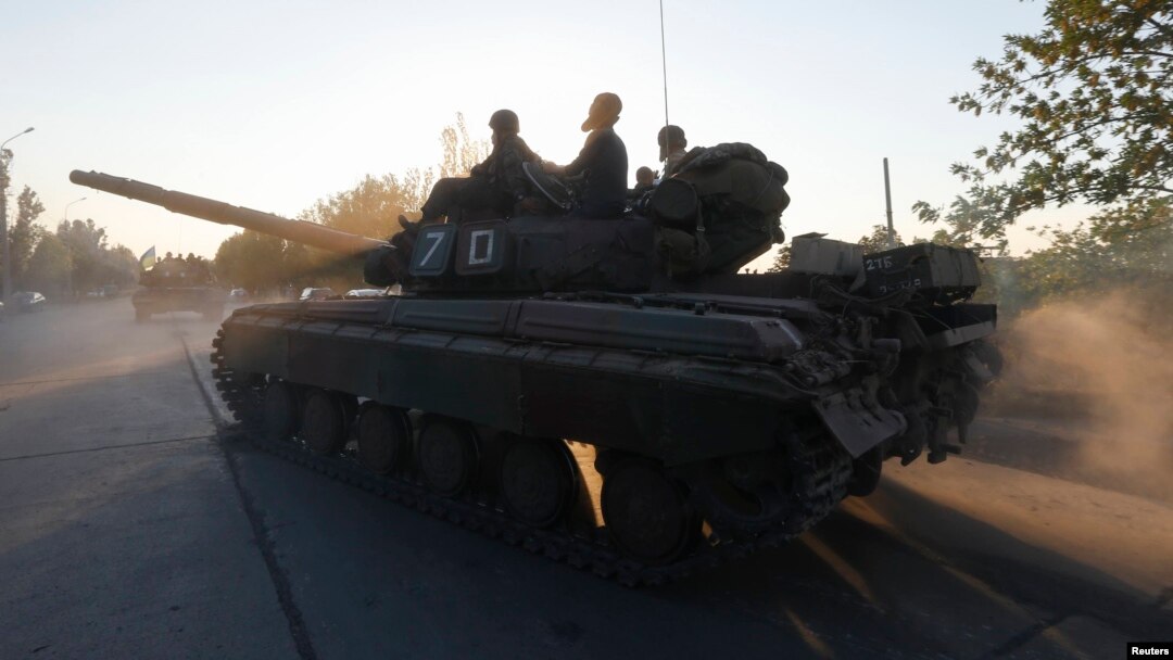 Ukrainian servicemen ride a tank in the southern coastal town of Mariupol on September 5.