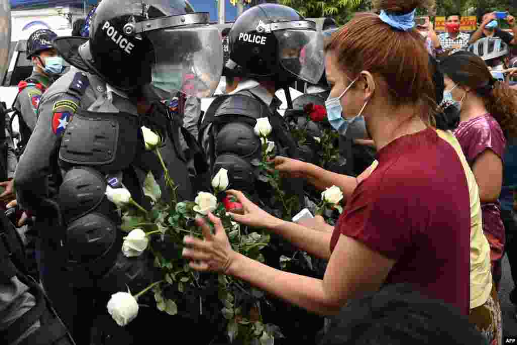 Протестующие дарят белые цветы полиции в Янгоне 6 февраля. Фотография очень напоминает сцены в Минске в начале осени 2020 года 