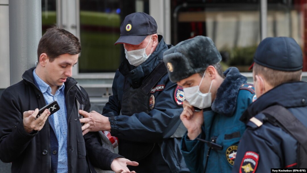 Moscow police officers stop a man for allegedly breaking self-isolation rules amid a coronavirus lockdown on April 9.