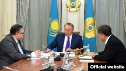 Қазақстан президенті Нұрсұлтан Назарбаев (ортада) президент әкімшілігінің жетекшісі Әділбек Жақсыбеков (сол жақта) пен оның орынбасары Марат Тәжинді қабылдап отыр. Астана, 26 қазан 2017 жыл.