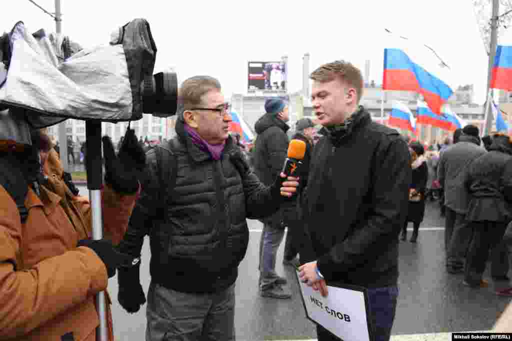 Азаттықтың Орыс қызметінің тілшісі Мумин Шакиров шеруге қатысушыдан сұхбат алып тұр.