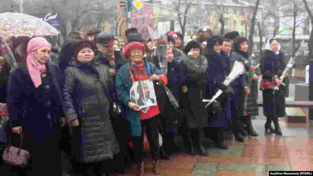 В центре собравшихся на церемонию можно увидеть гражданскую активистку Сахиб Жанабаеву. Она держит портрет диссидента Арона Атабека, более десяти лет находящегося в тюрьме после событий в поселке Шанырак вблизи Алматы в июле 2006 года. 