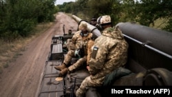 Украинские артиллеристы сидят на самоходной 203-мм пушке «2С7 Пион» на южном фронте Украины. 14 сентября 2022 года