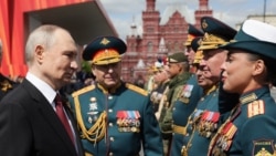 На фотографии, распространенной российским государственным агентством Sputnik, президент России Владимир Путин приветствует военачальников после военного парада Победы на Красной площади в Москве 9 мая