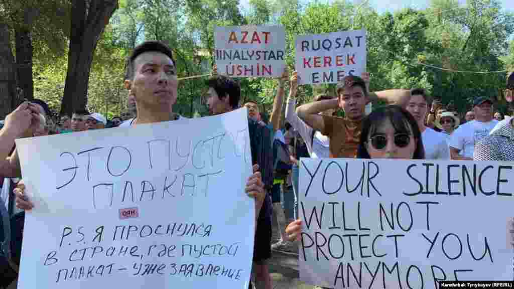 "Үнсіздік ендігәрі сені қорғай алмайды" деген жазуы бар плакат ұстап тұрған азамат. 