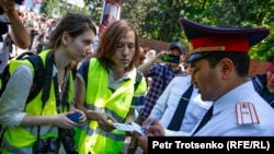 Полицейские проверяют документы журналистов во время празднования Дня Победы в Алматы, 9 мая 2019 года.