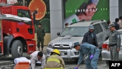 Rescue personnel take away the body of a bomb blast victim near the main gate of a supermarket in Kabul.